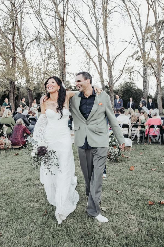 Very happy bride and groom with guest in the background.