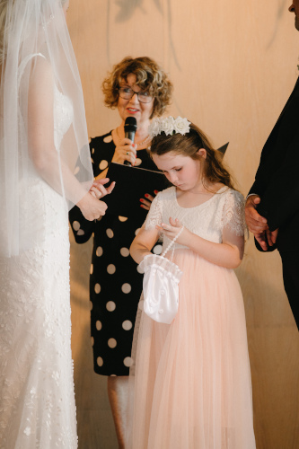 The flower girl getting the ring out of a white satin bag.