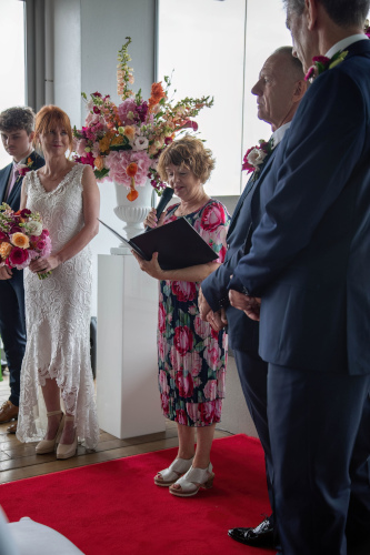 Debbie addressing the congregation with the wedding party looking on.