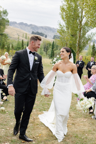 The bride and groom walking up the outside aisle after the ceremony.
